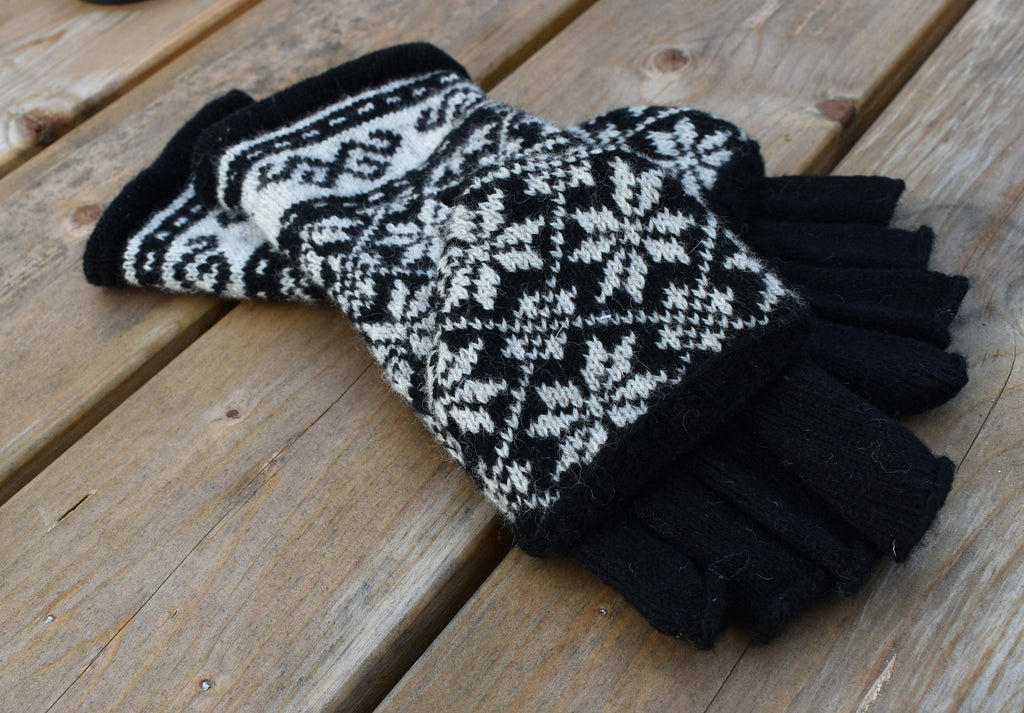 Pair of black and white patterned gloves on a wooden surface