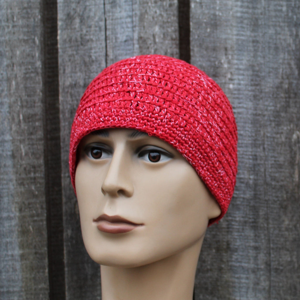 Red knitted beanie on a mannequin head against a wooden background