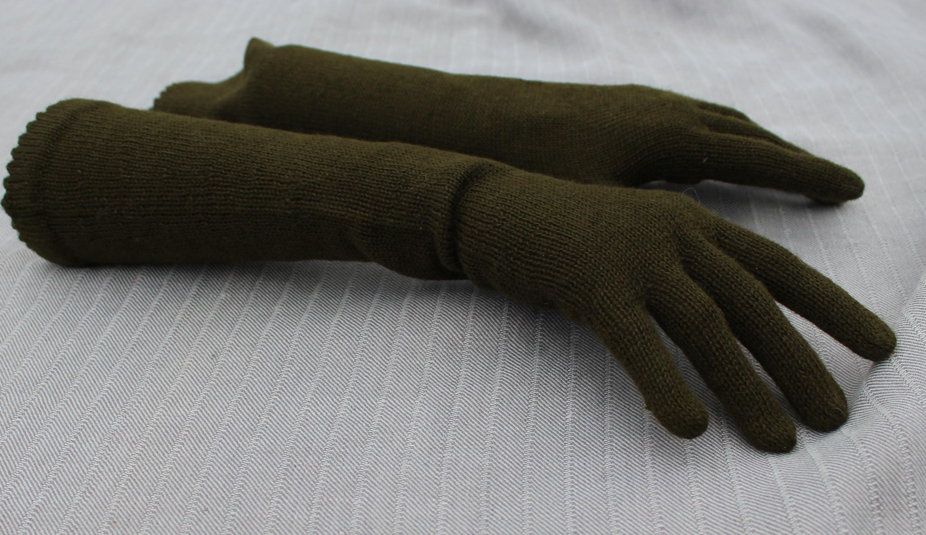 Pair of green gloves on a light gray background