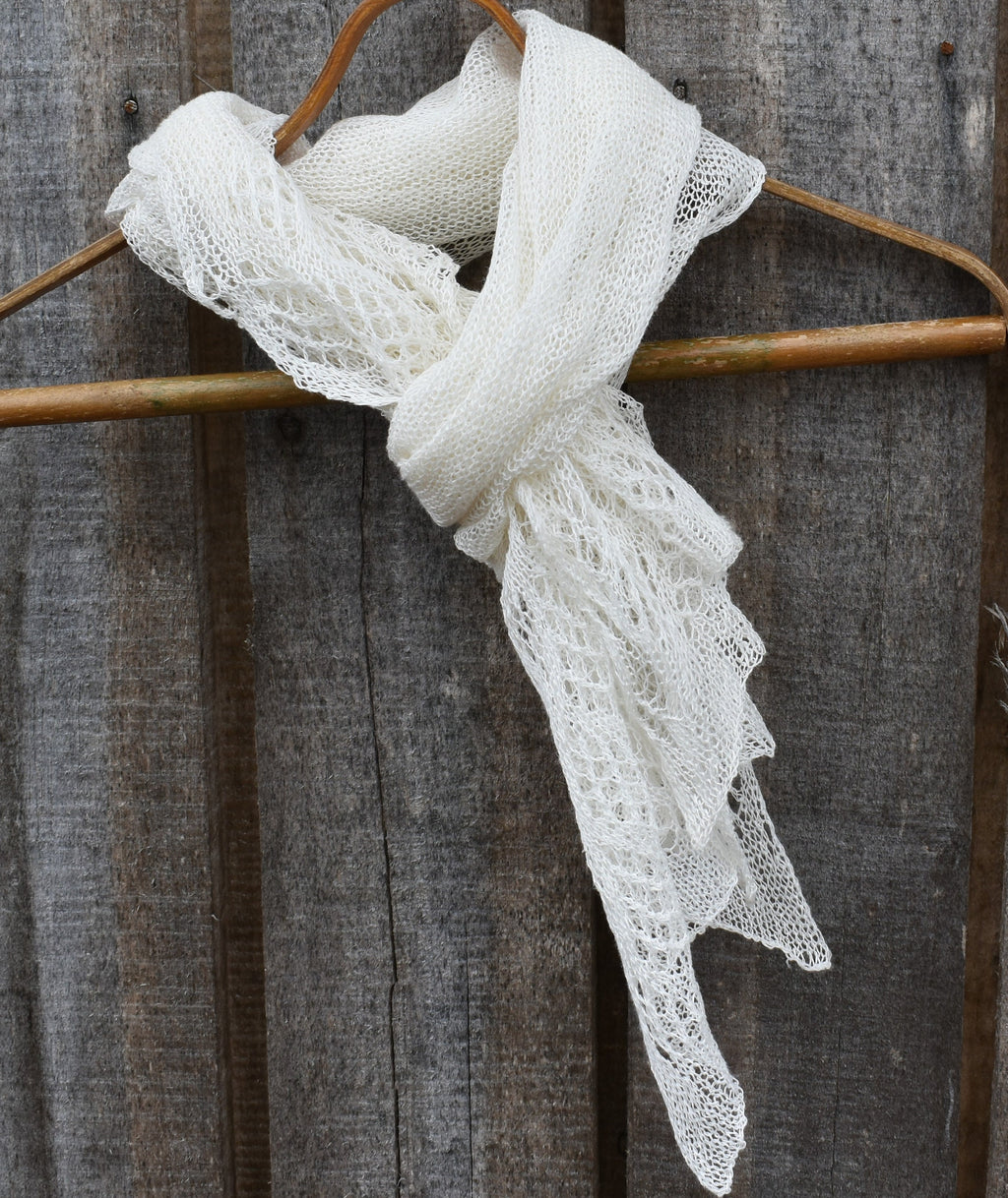 White lace scarf on a wooden hanger against a rustic wooden background