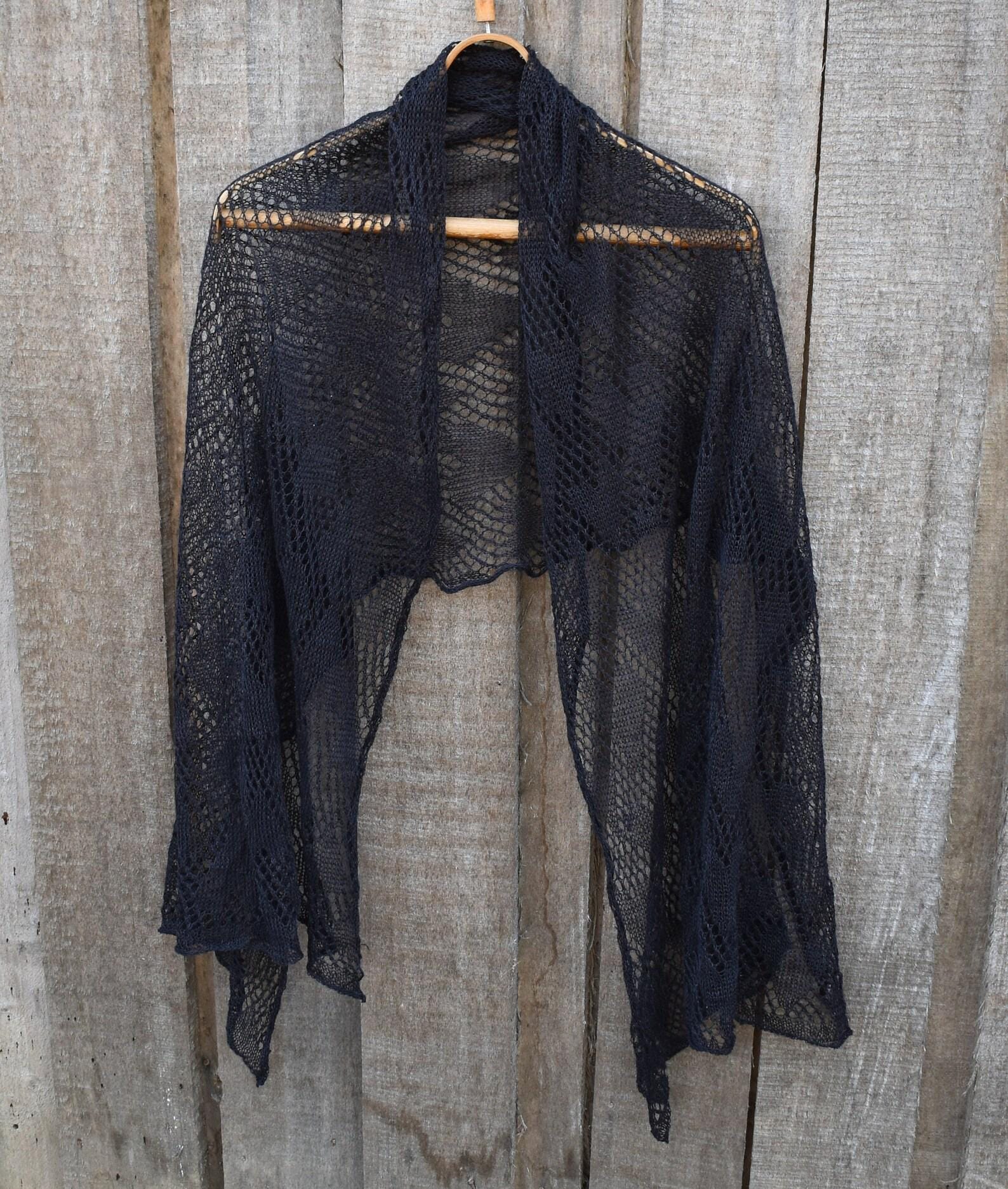 Black linen shawl on a wooden hanger against a wooden background