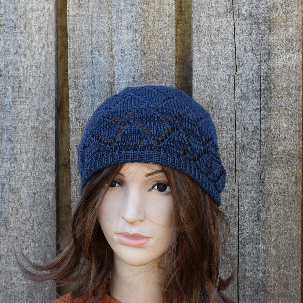 Blue knitted hat on a mannequin head against a wooden background