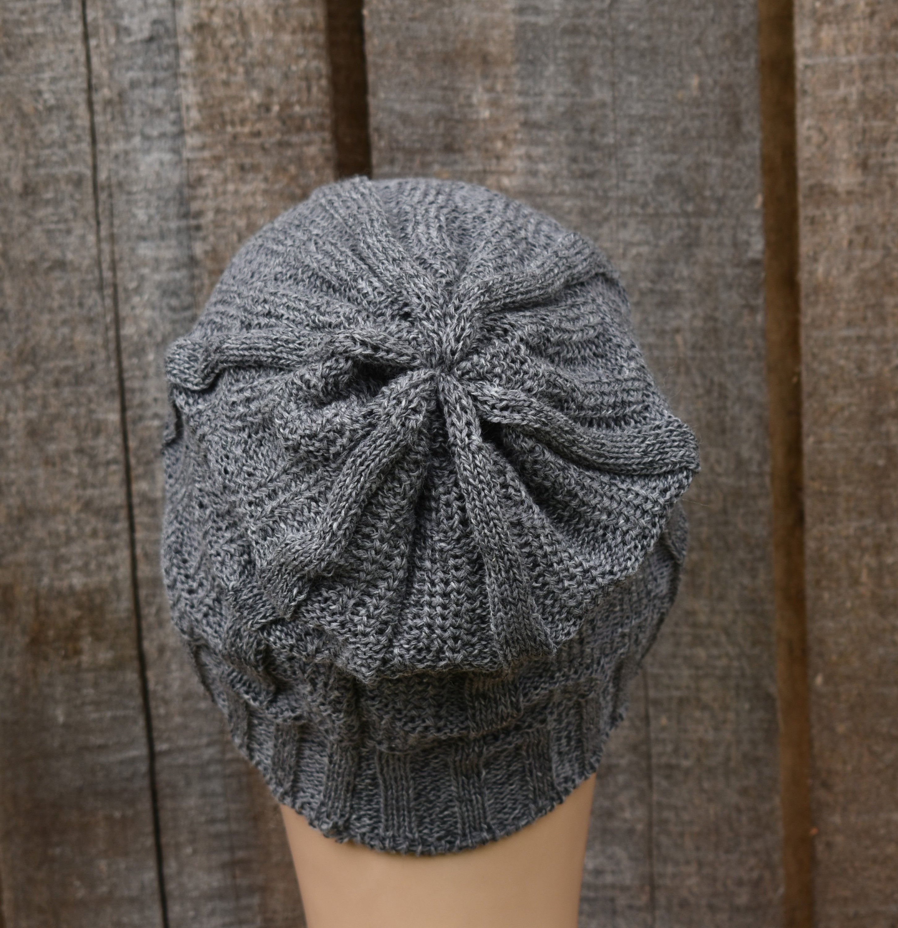 Gray knit beanie on a mannequin head against a wooden background