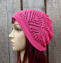 Pink knitted hat on a mannequin head against a wooden background