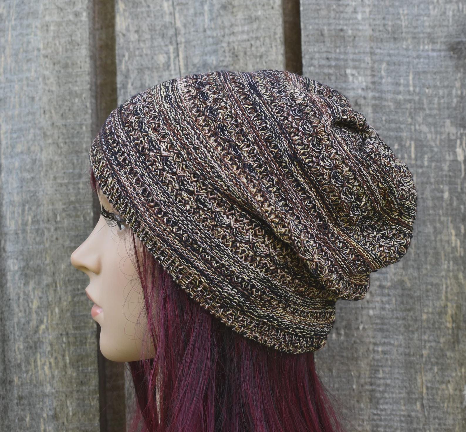 Knitted beanie worn by a person with purple hair against a wooden background