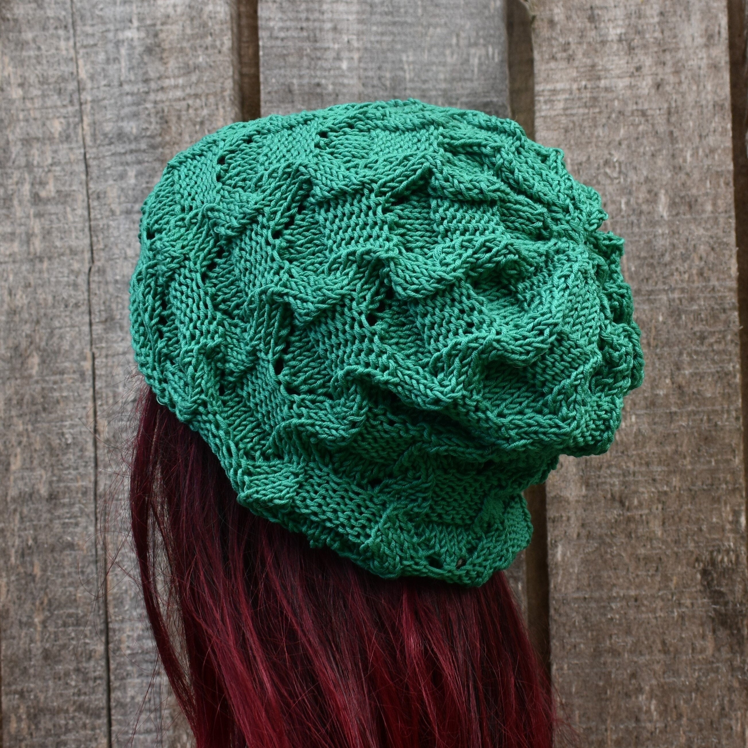 Green knitted beanie on a wooden surface