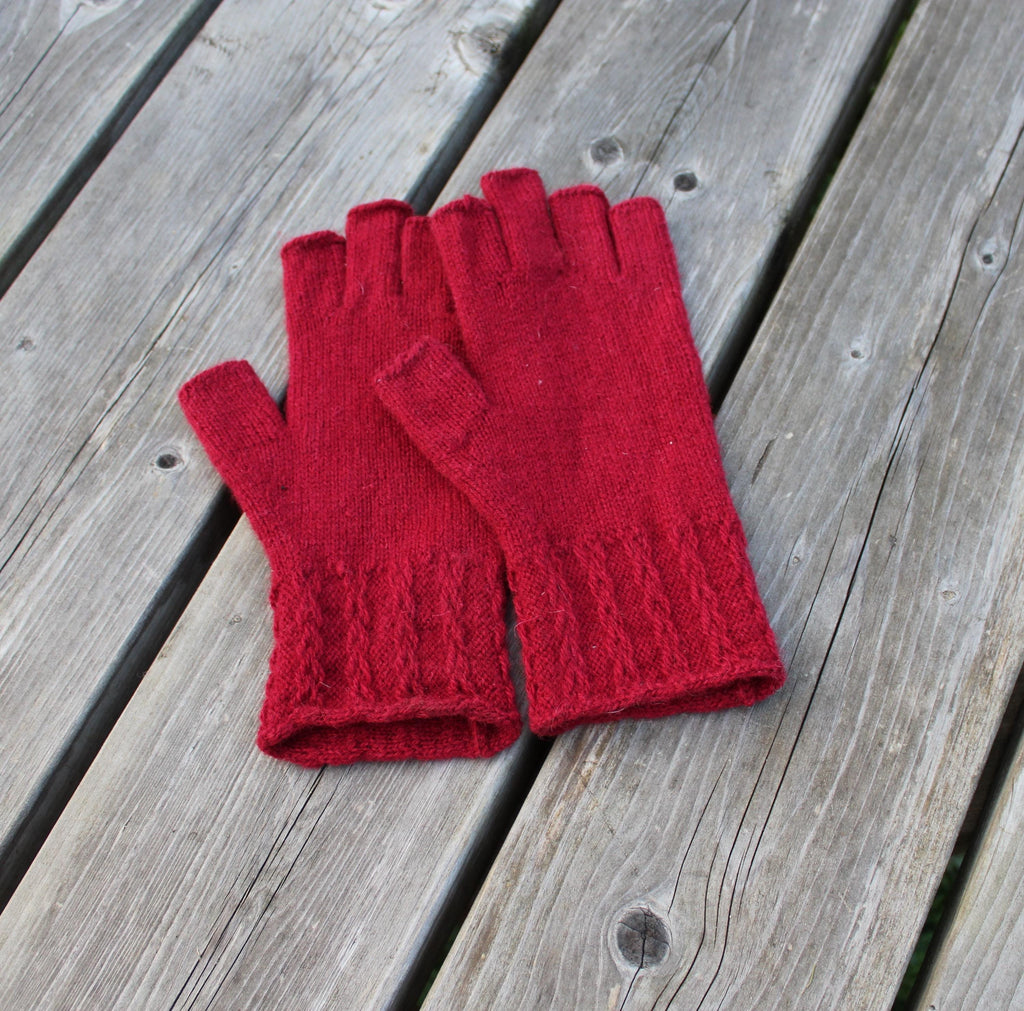 Red knitted gloves on a wooden surface