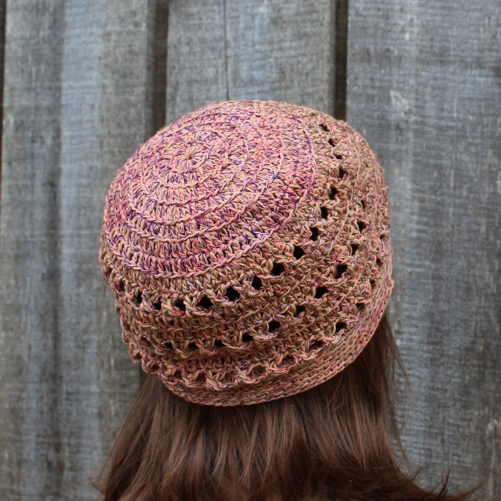 Crocheted hat worn by a person against a wooden background