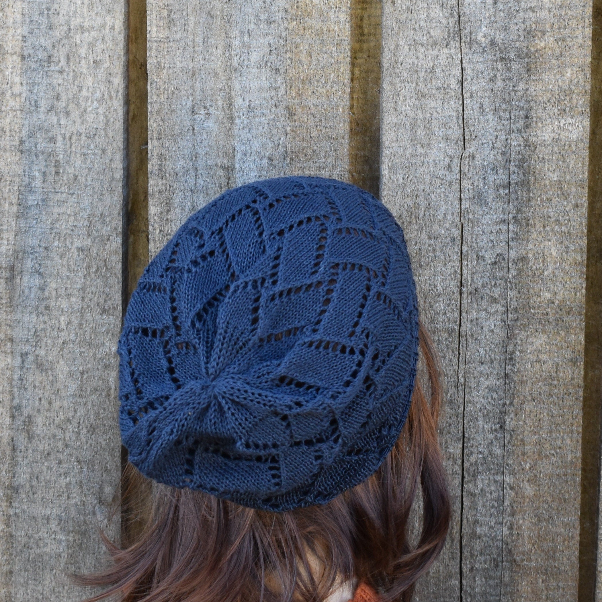 Light weight knitted beanie on a person with wooden planks in the background