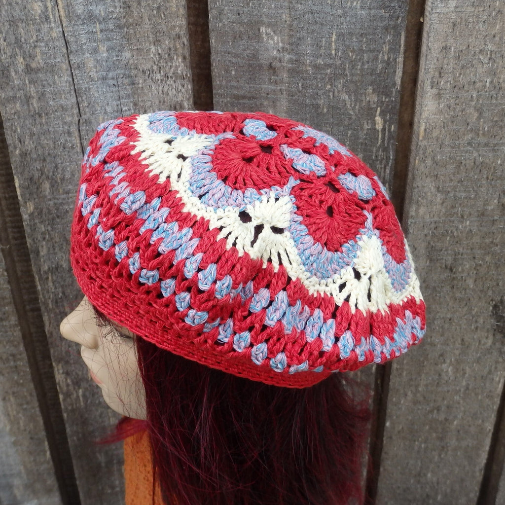 Colorful crocheted hat on a mannequin head against a wooden background