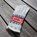 Knitted glove with a colorful pattern on a wooden surface