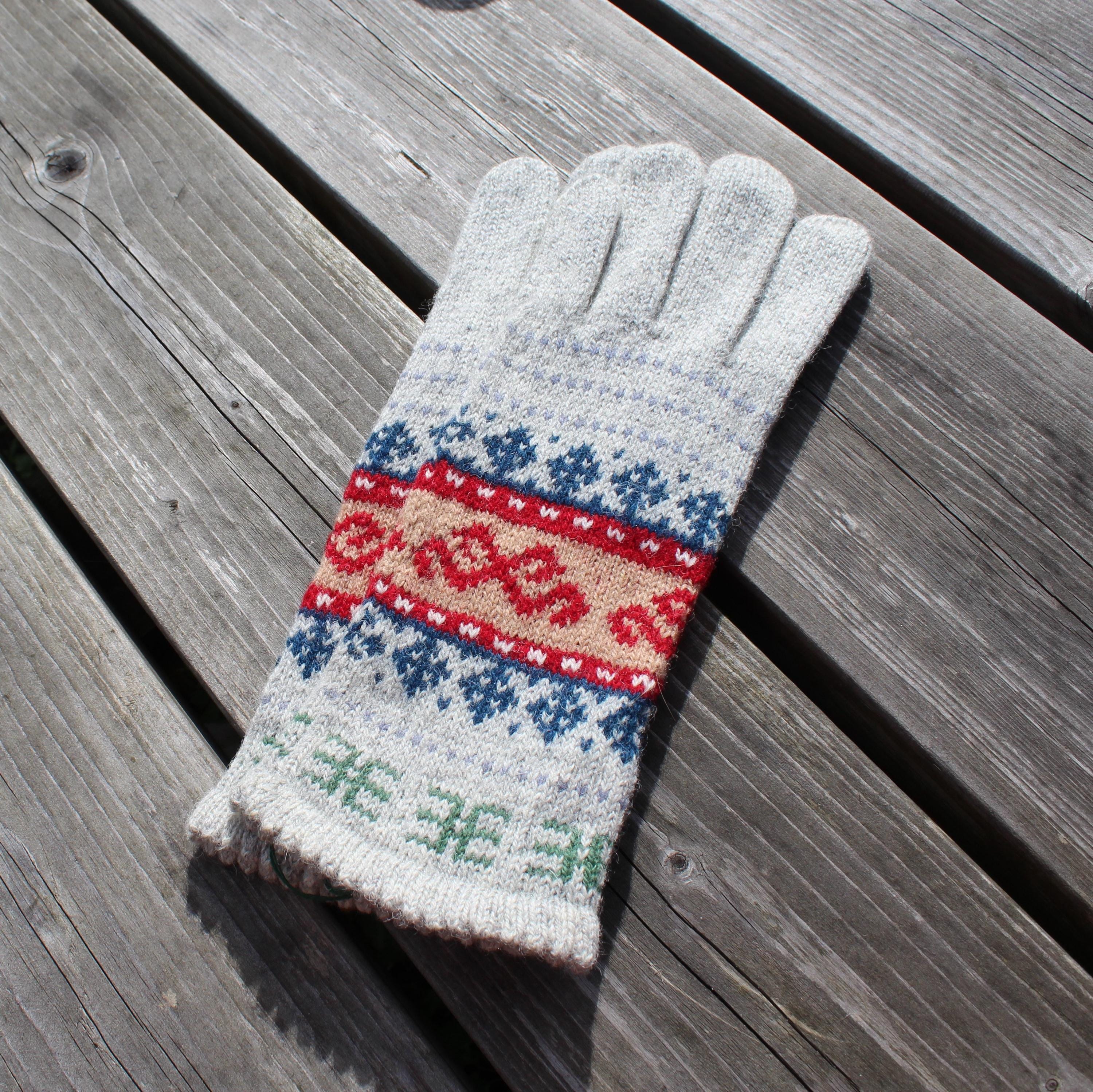 Knitted glove with a colorful pattern on a wooden surface