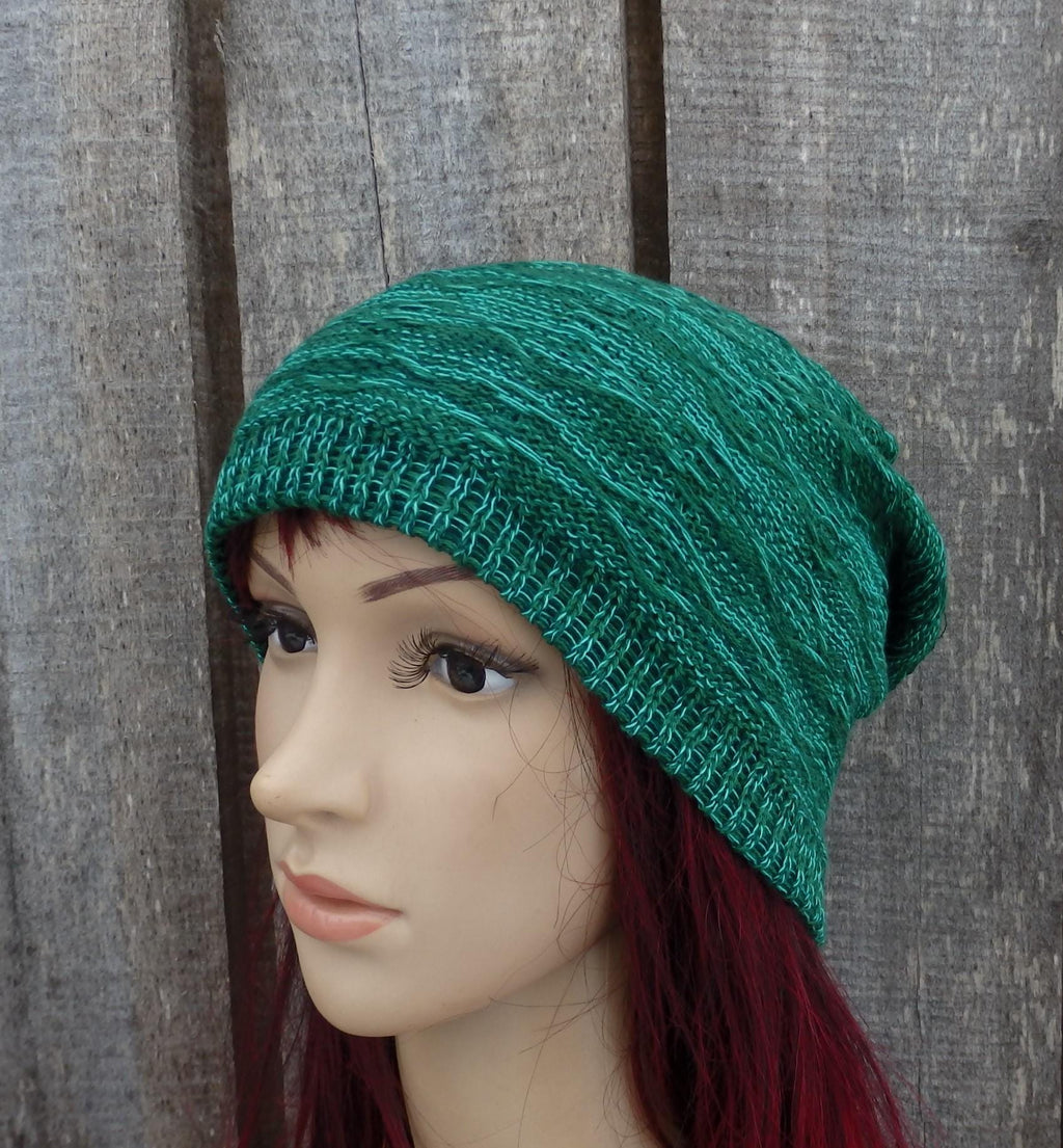 Teal knitted beanie on a mannequin head against a wooden background