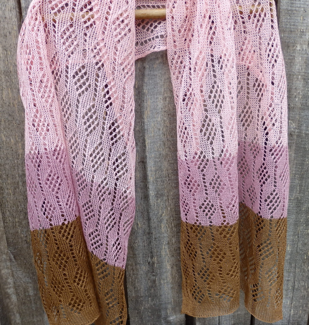 Pink and brown knitted shawl on a wooden surface