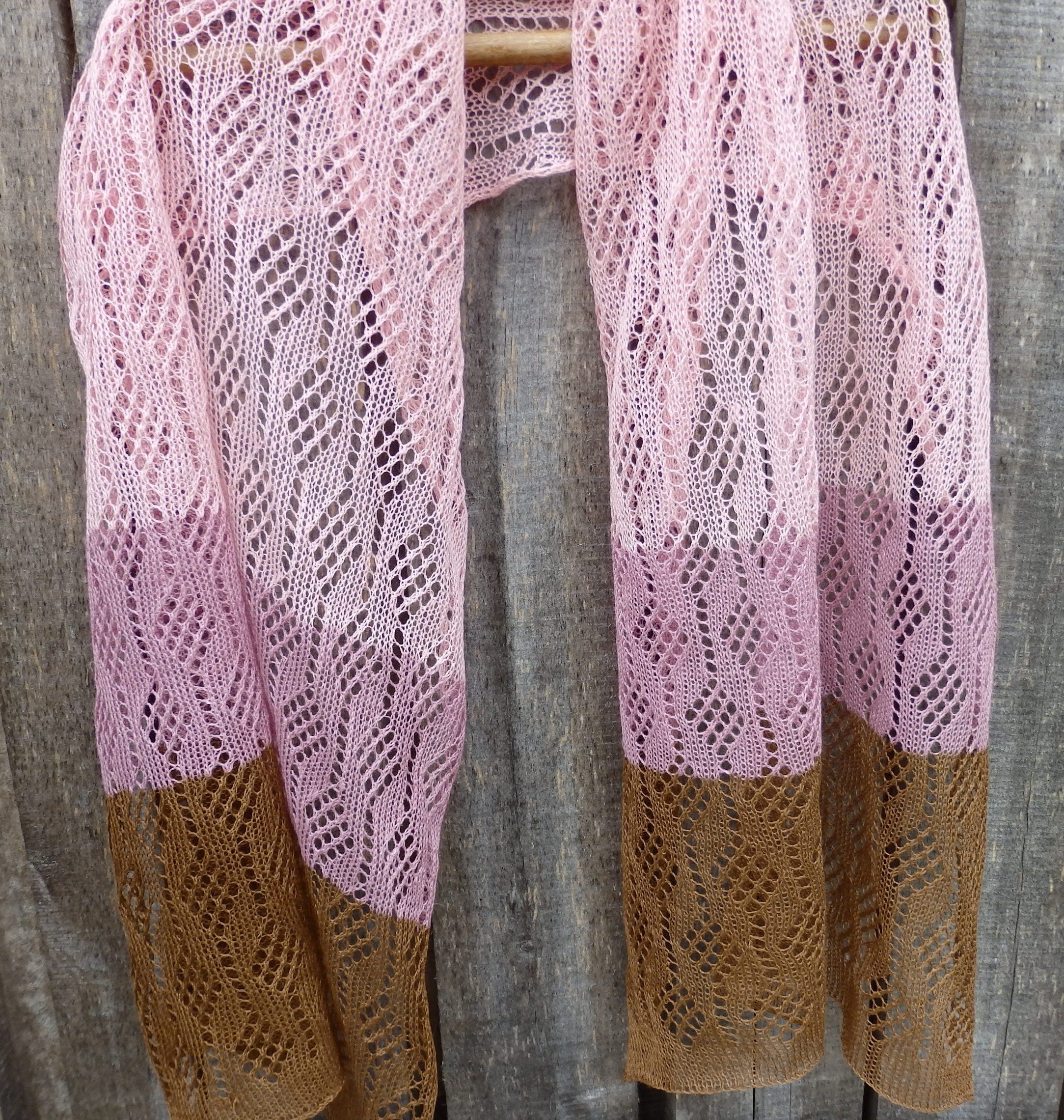 Pink and brown knitted shawl on a wooden surface