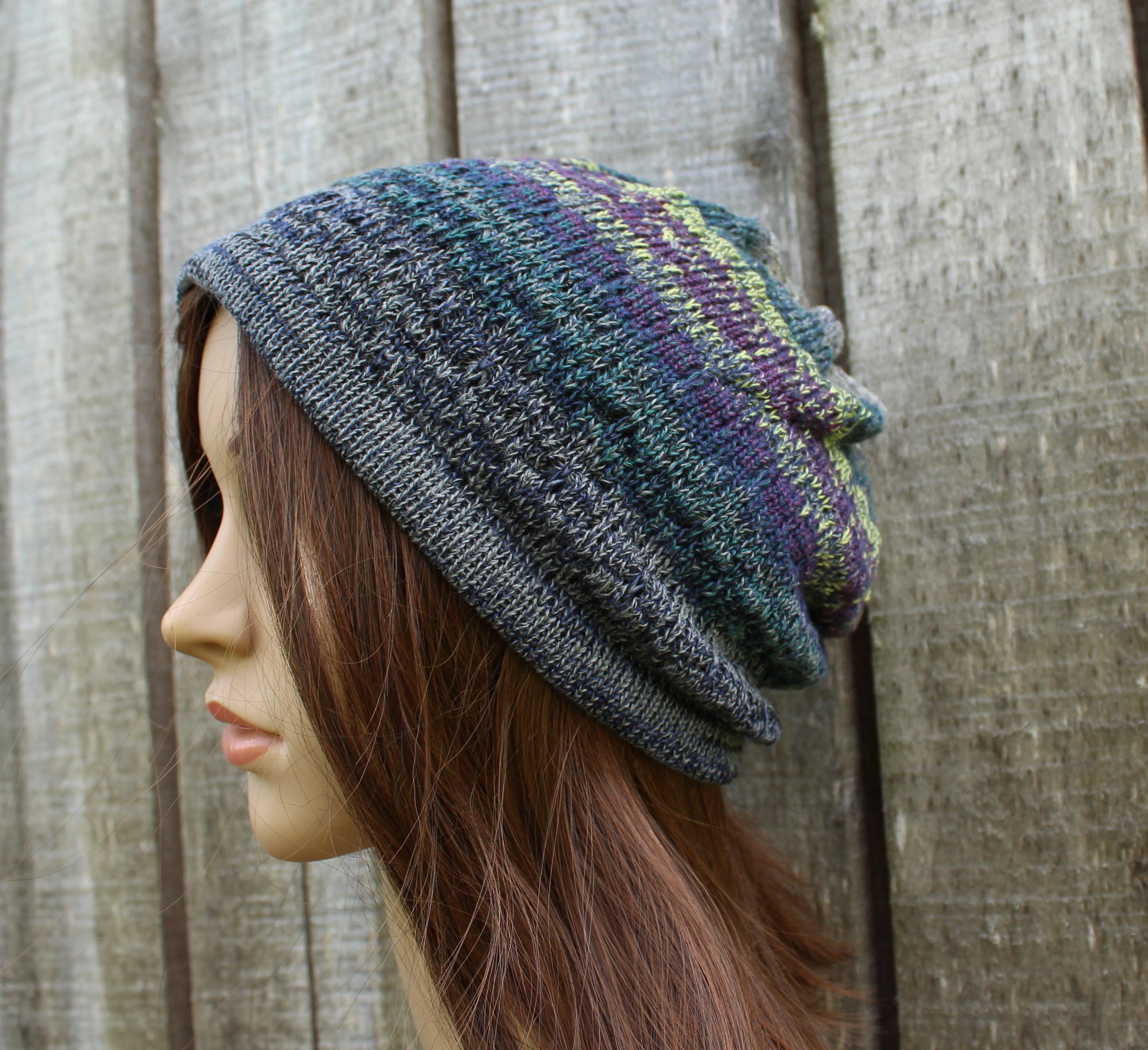 Knitted beanie on a mannequin head against a wooden background