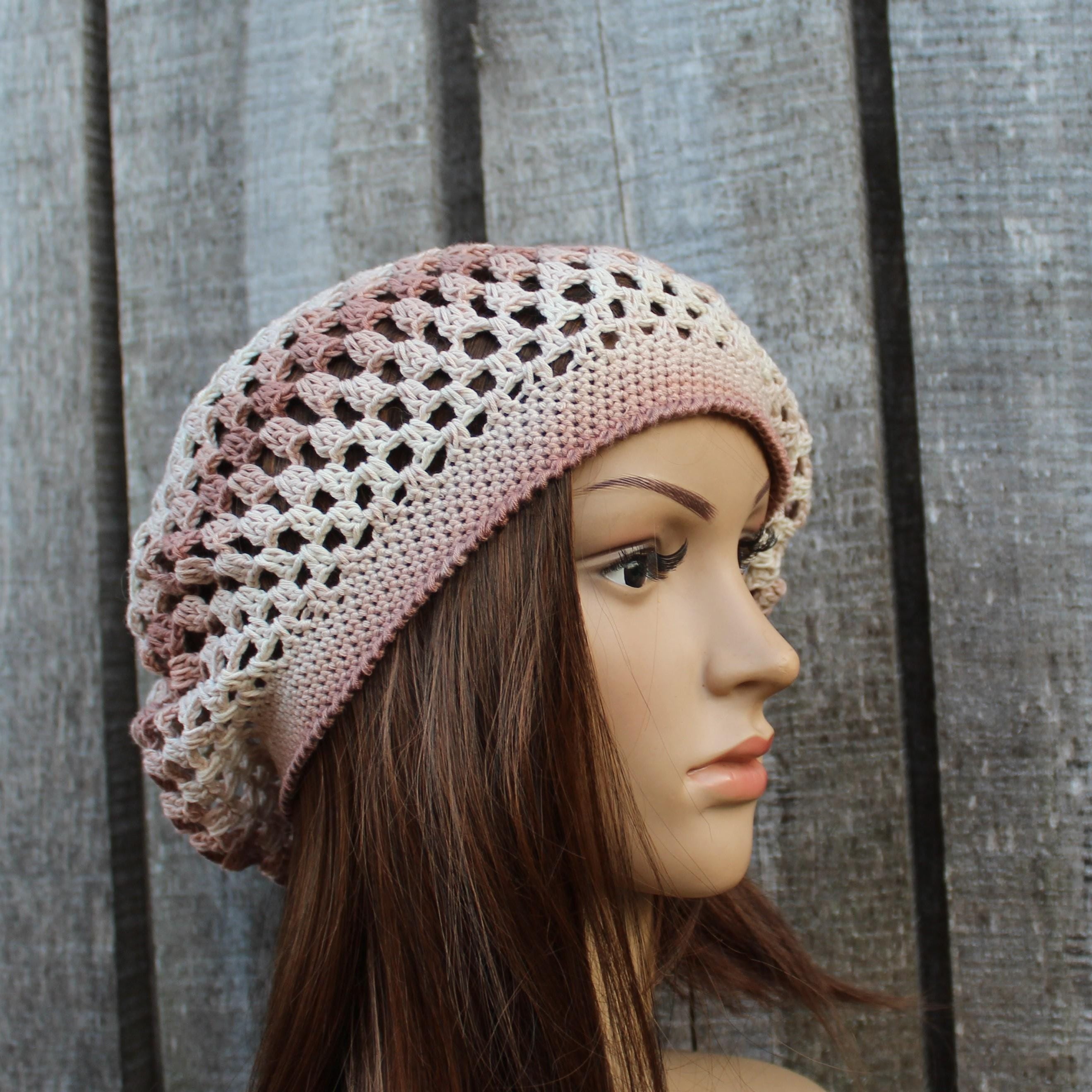 Mannequin head wearing a crocheted beanie with a wooden background