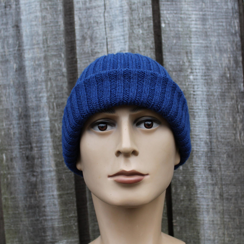 Blue knitted beanie on a mannequin head against a wooden background