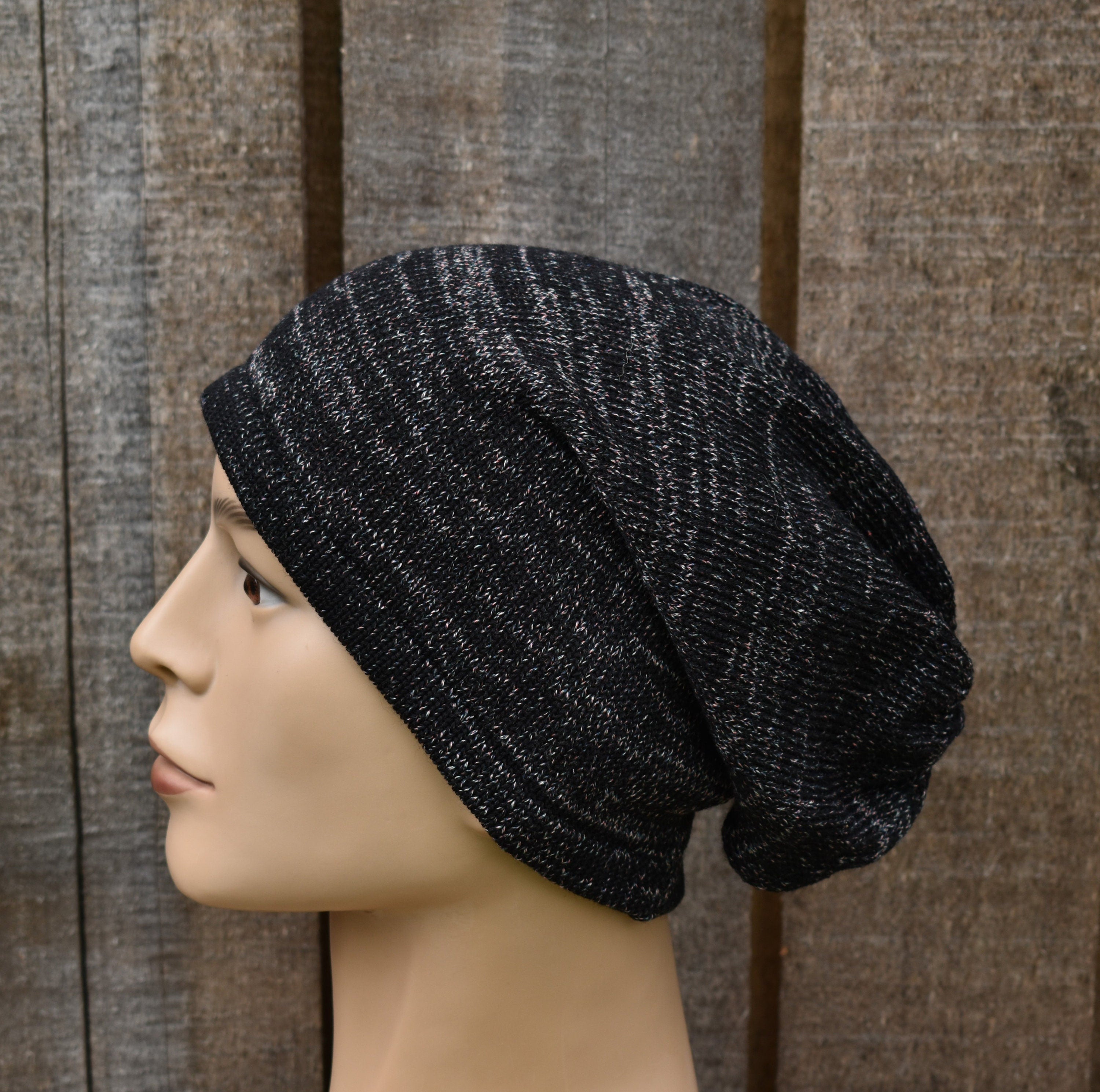 Black knit beanie on a mannequin head against a wooden background