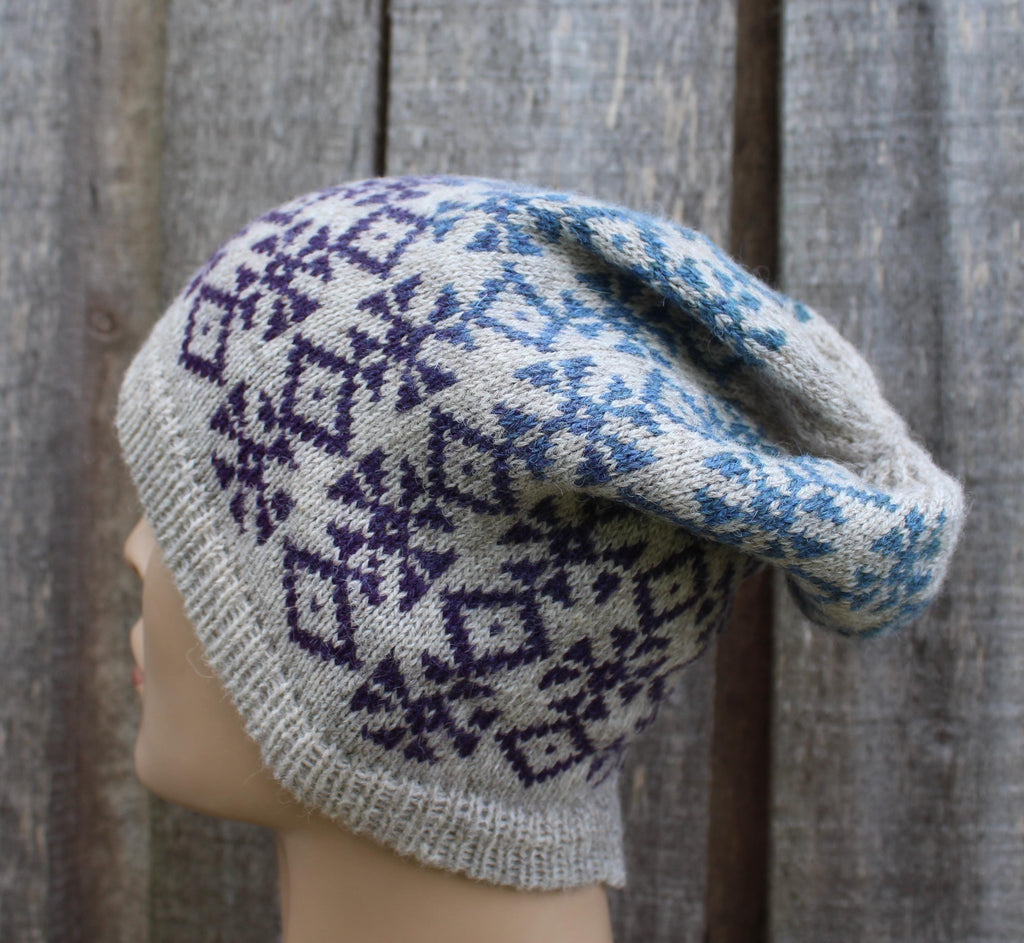 Knitted hat with a pattern on a mannequin head against a wooden background