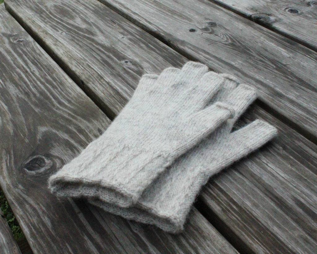 Pair of gray gloves on a wooden surface