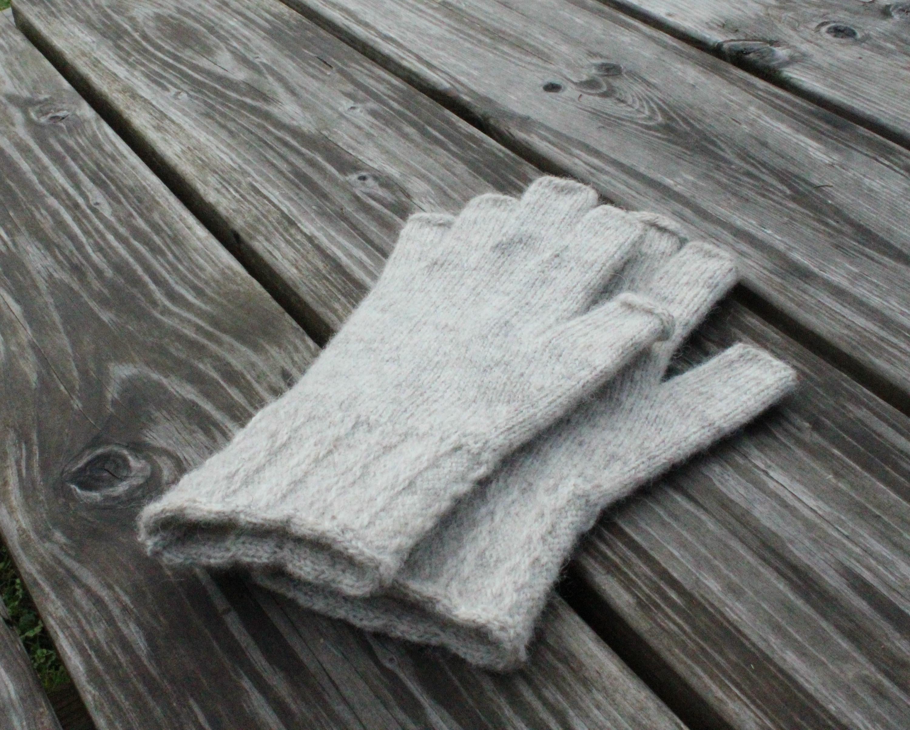 Pair of gray gloves on a wooden surface