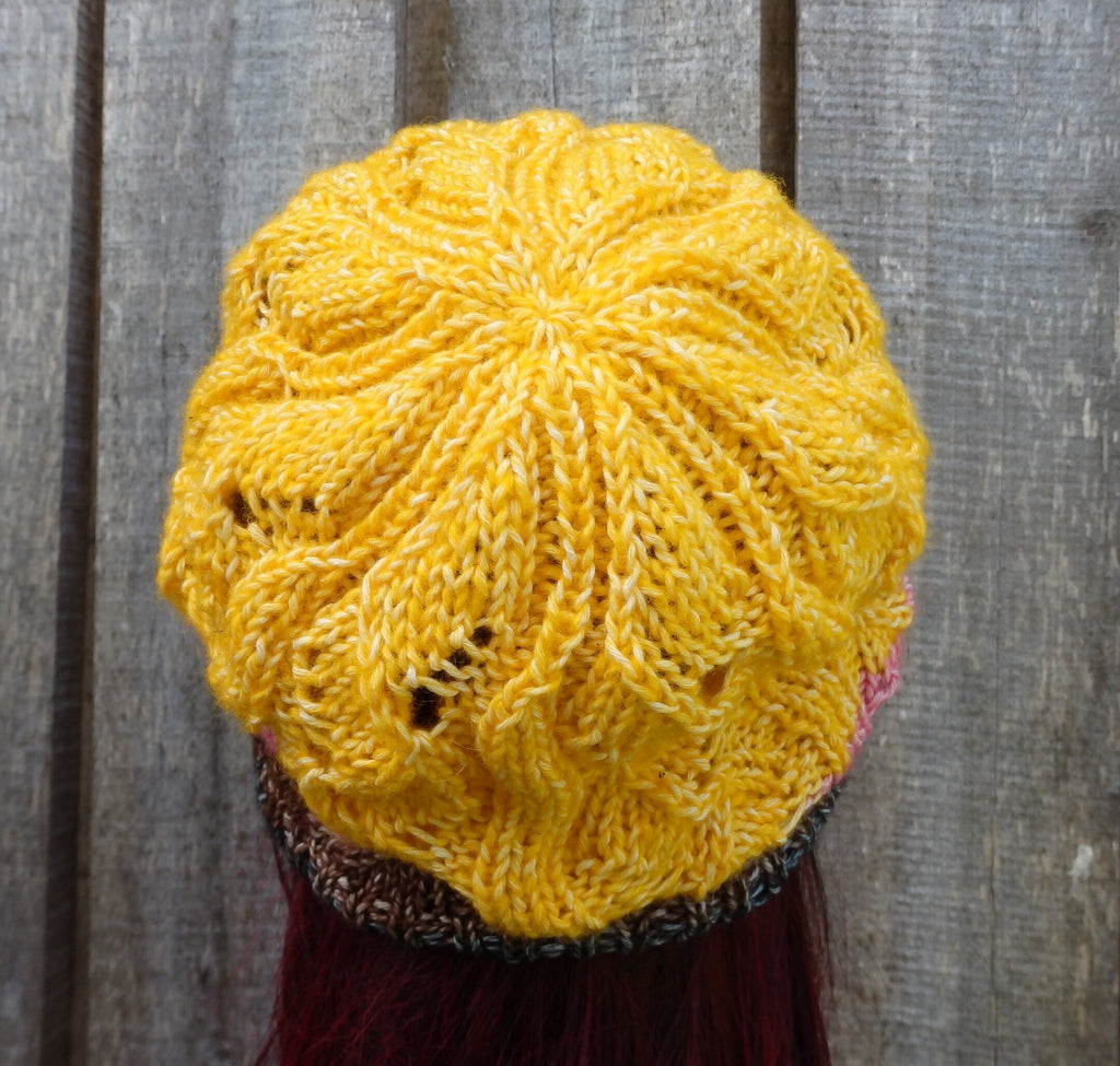 Yellow knitted hat on a wooden background