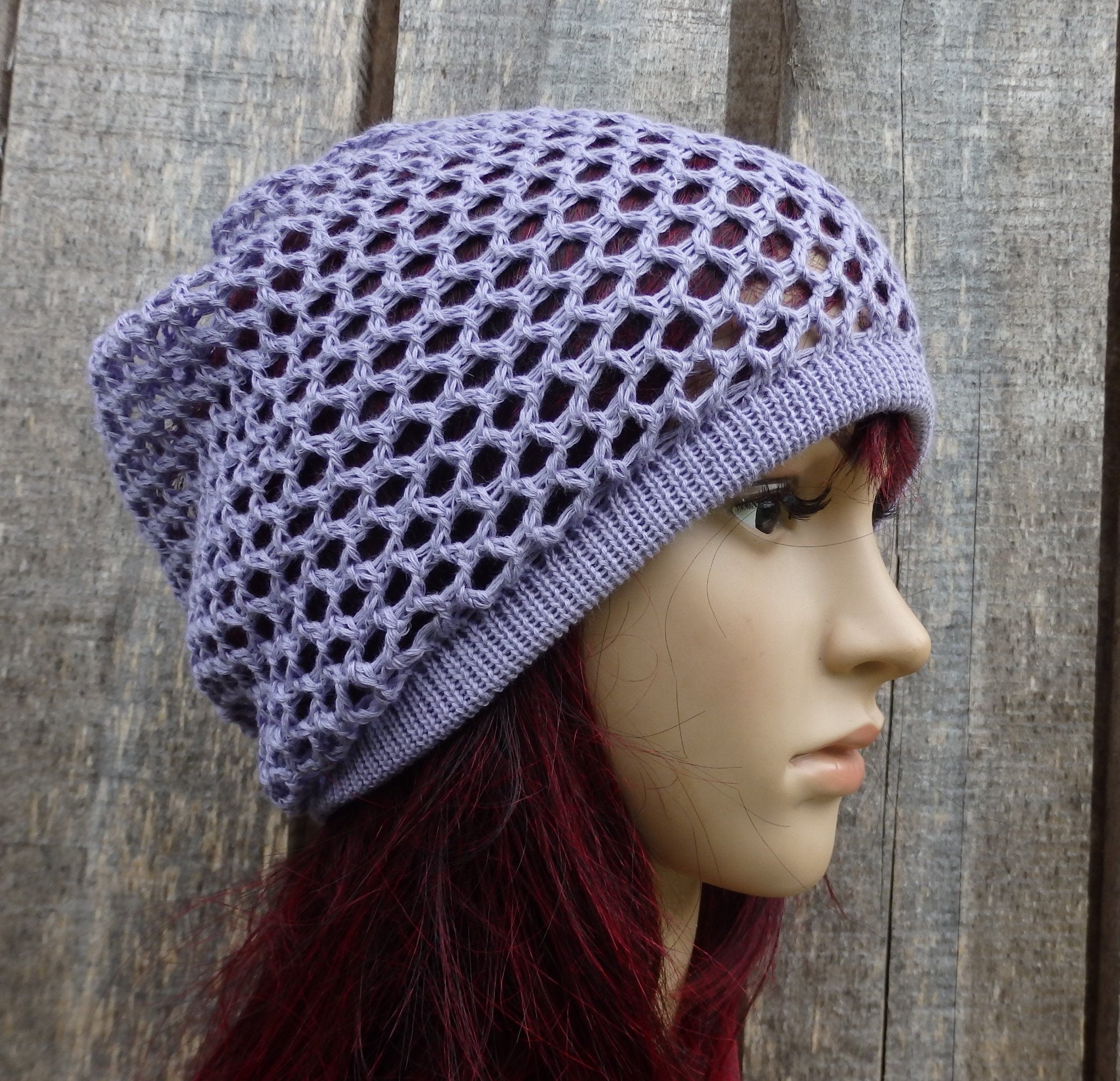 Purple knit hat on a mannequin head against a wooden background