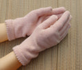Pair of pink gloves on a wooden surface