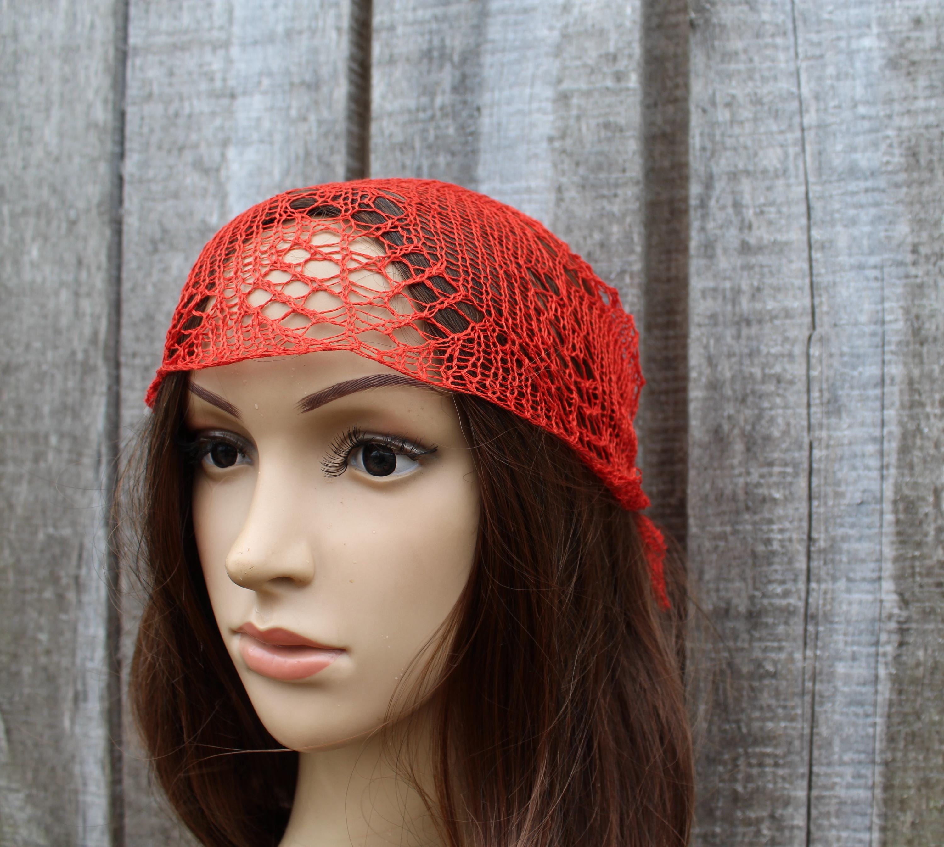 Red lace headband on a mannequin head against a wooden background