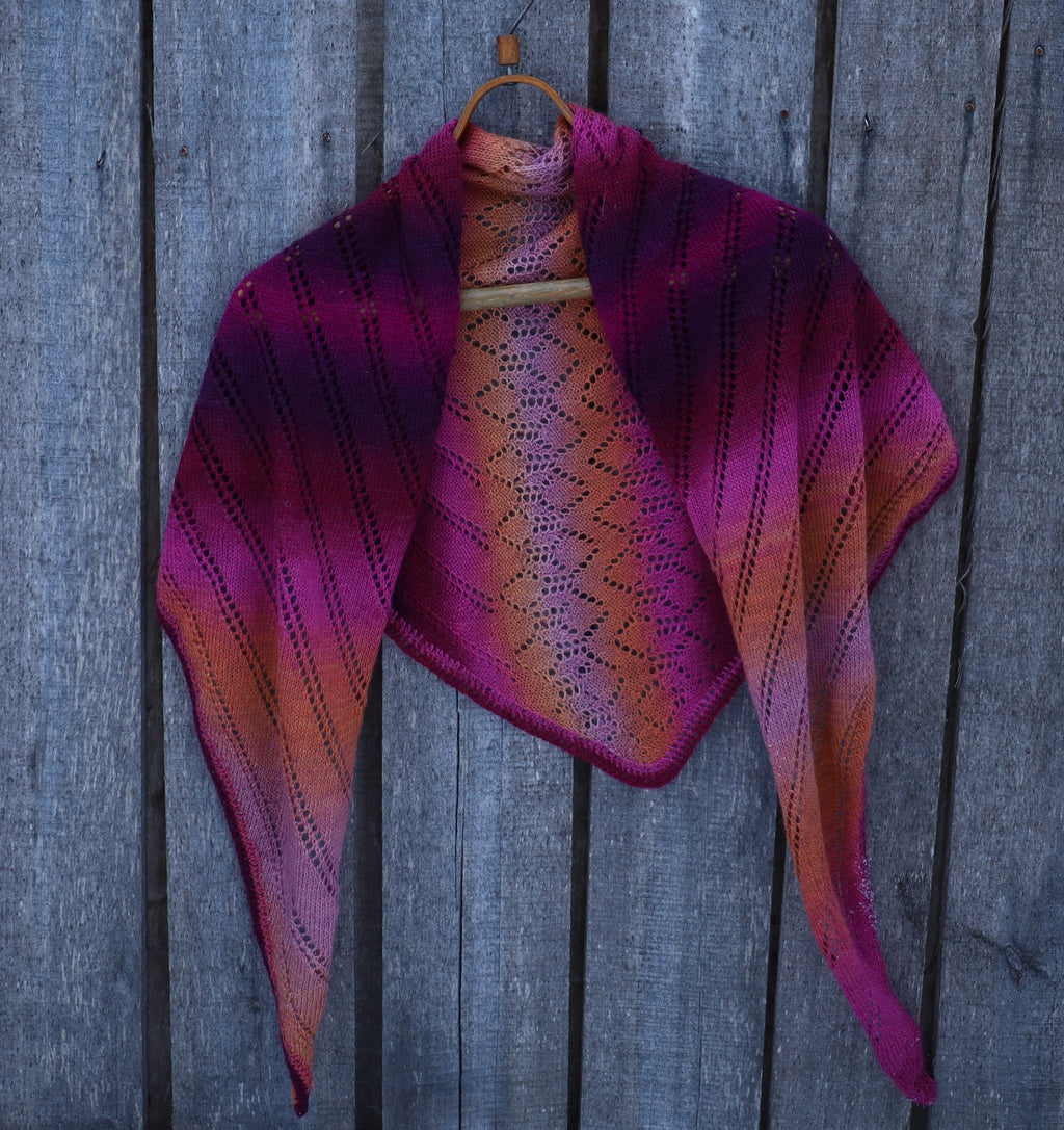 Knitted shawl with purple and pink gradient on a wooden background