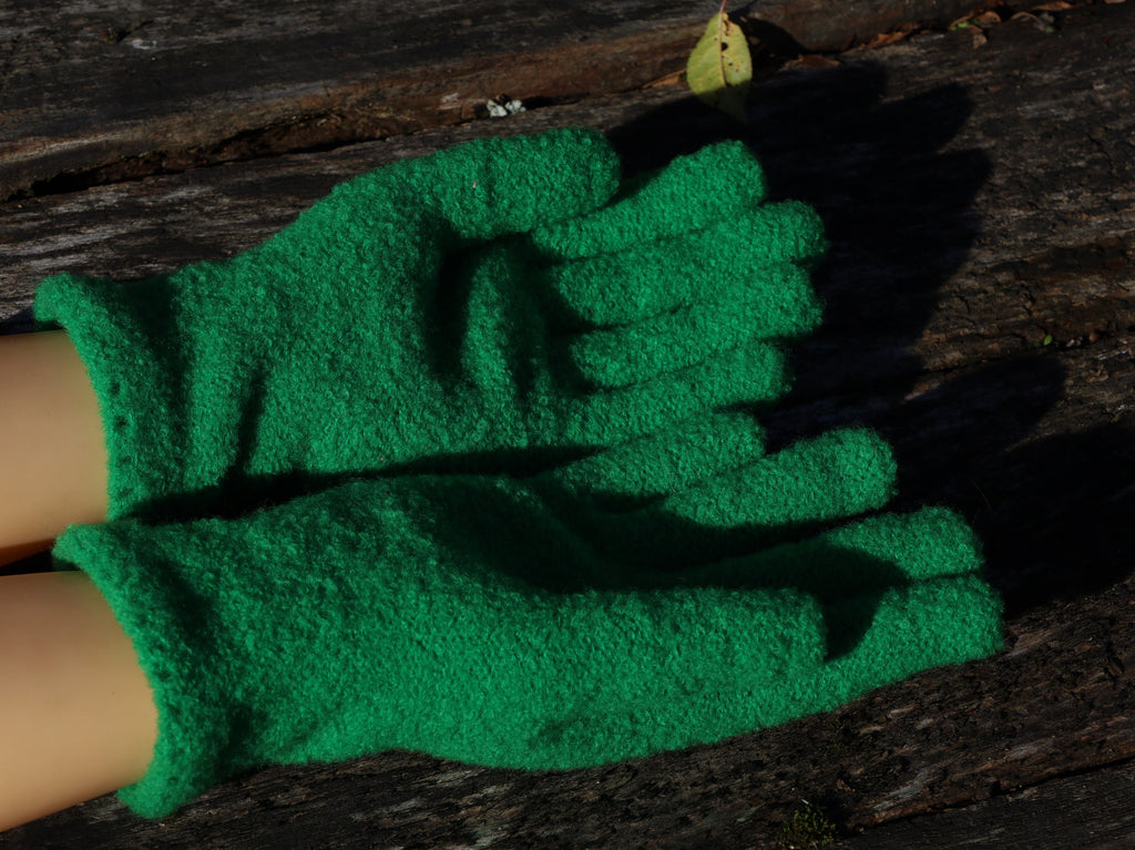 Green gardening gloves on a wooden surface