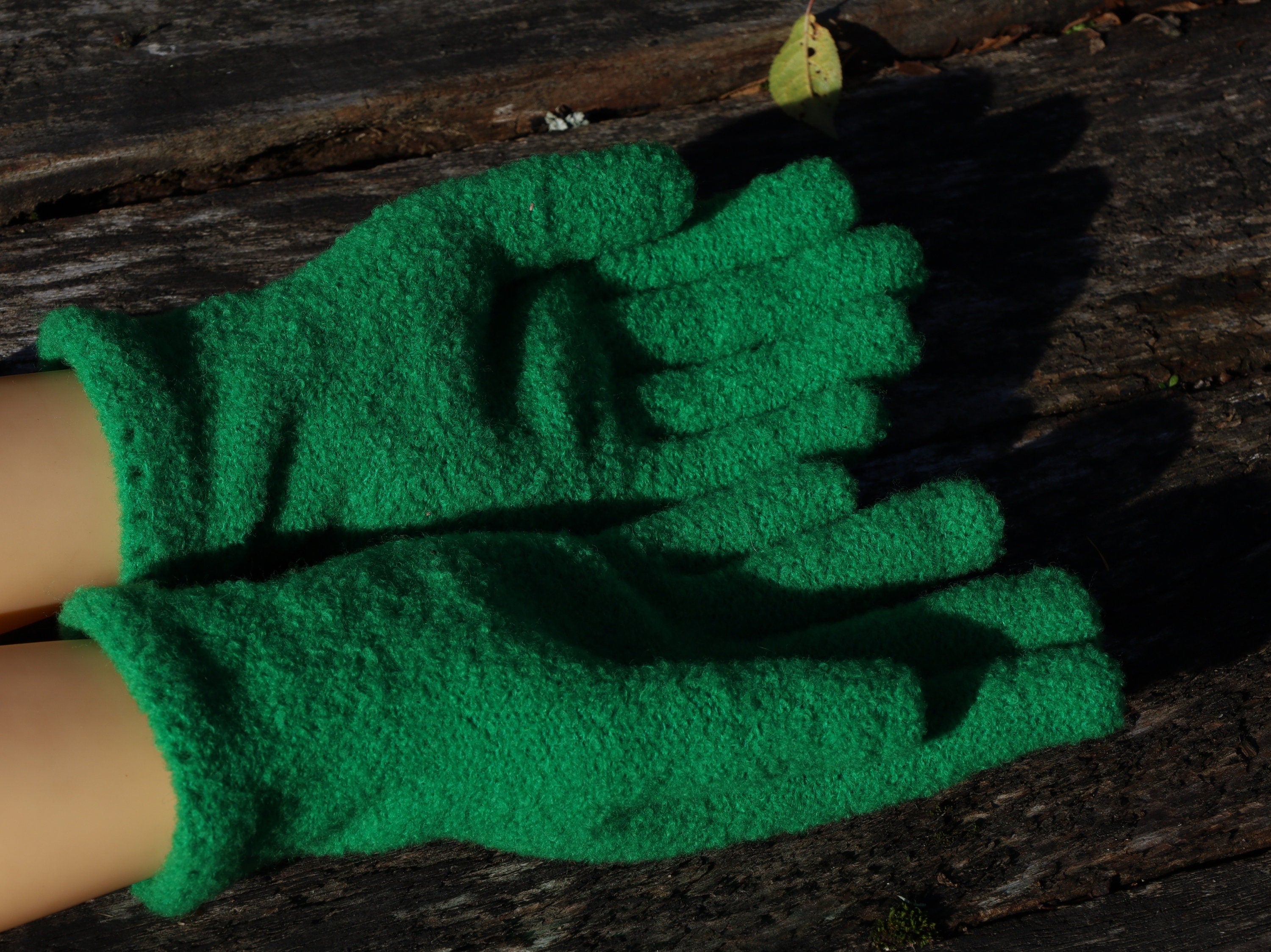 Green gardening gloves on a wooden surface
