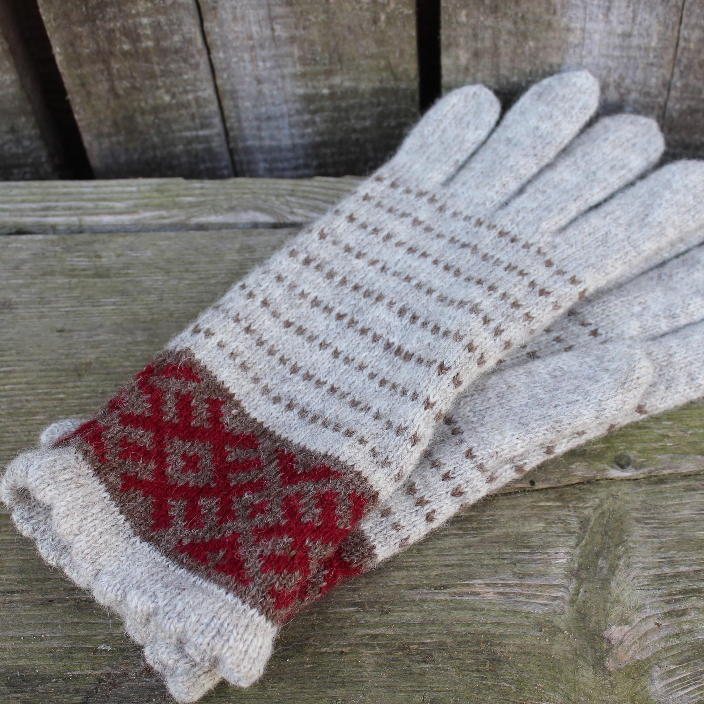 Knitted glove with a red and white pattern on a wooden surface