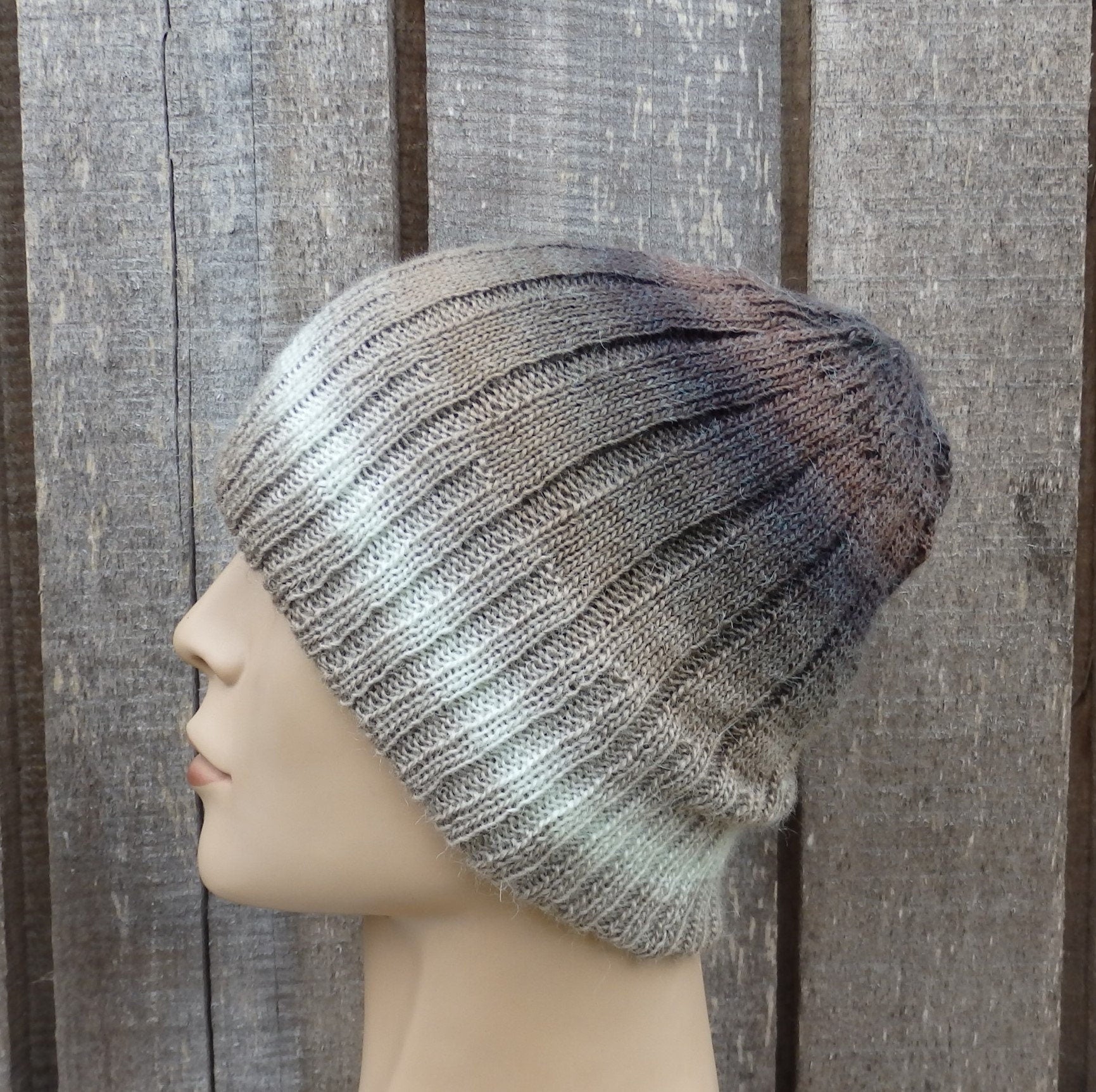 Knitted beanie on a mannequin head against a wooden background