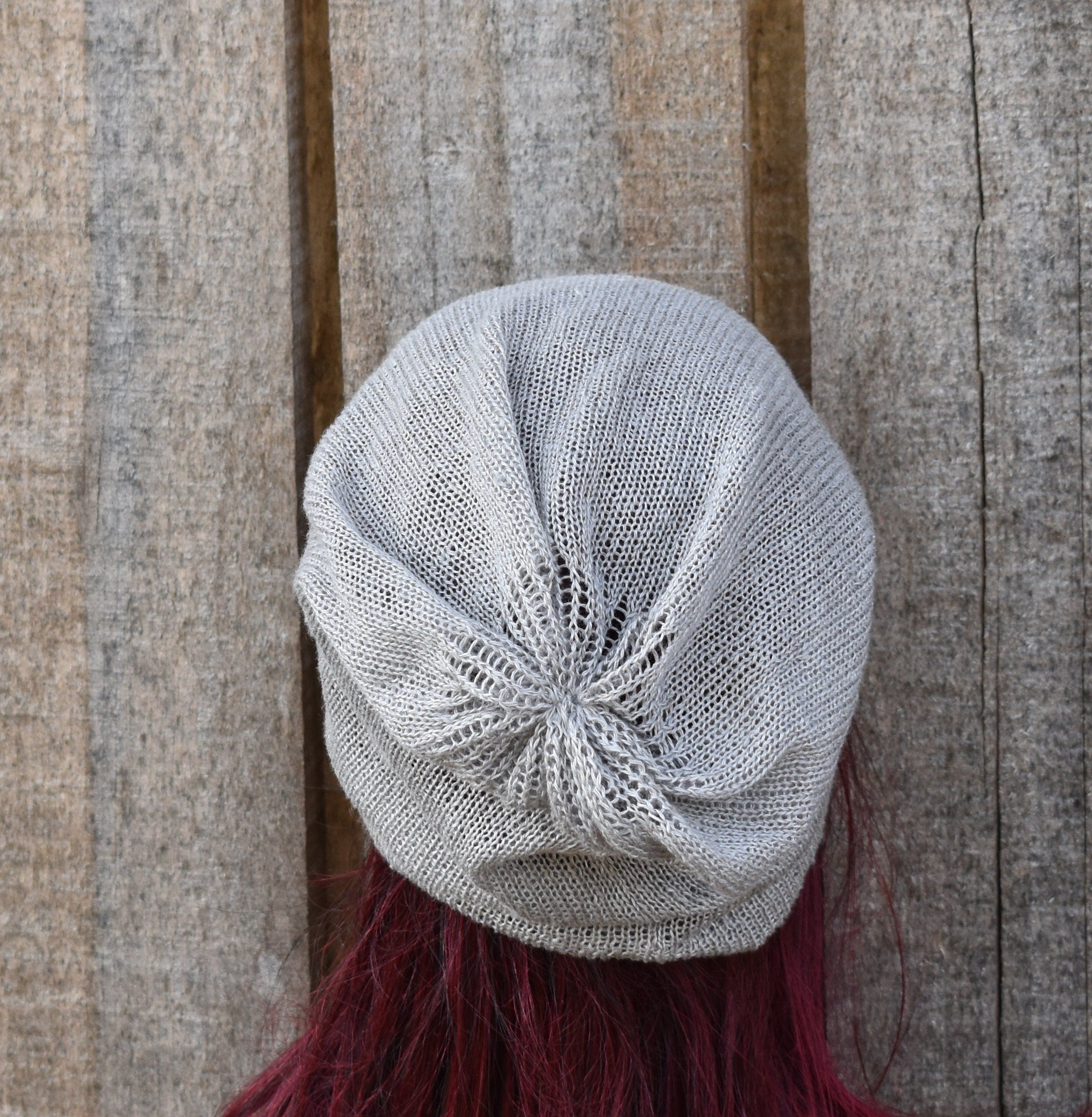 Knitted gray beret with a textured pattern on a wooden background