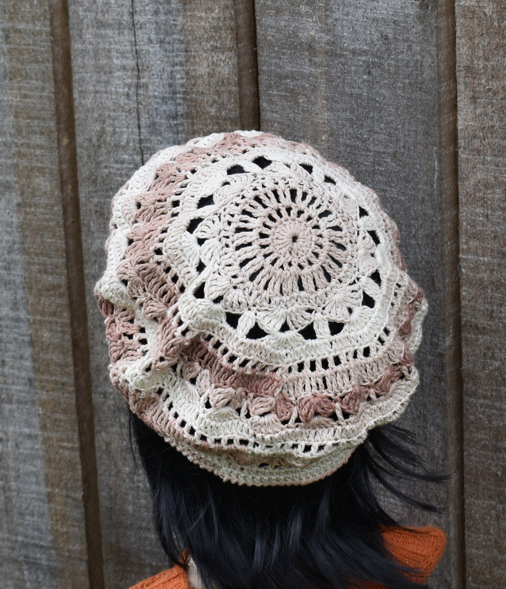 Crocheted headscarf with intricate pattern against a wooden background