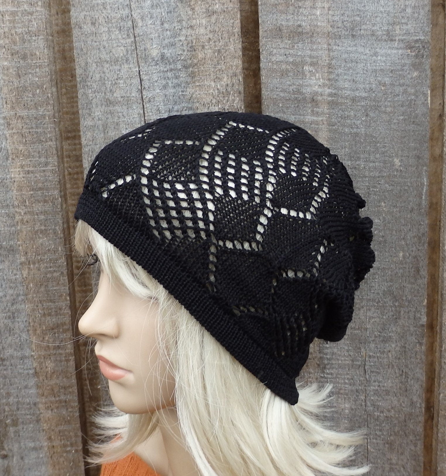 Black knit beanie on a mannequin head against a wooden background