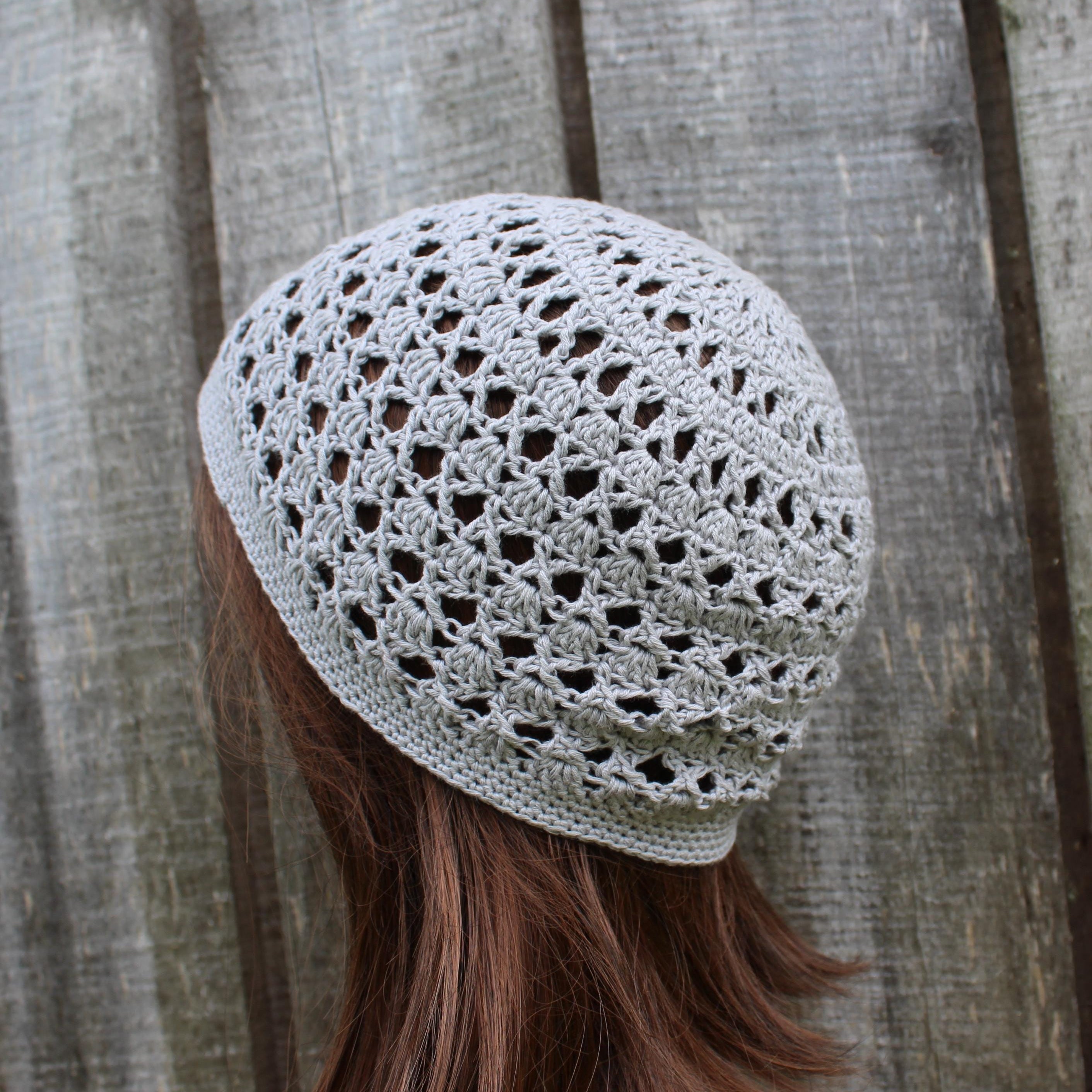 Crocheted beanie worn by a person with wooden background