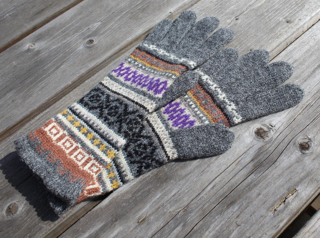 Pair of gray gloves with patterned cuffs on a wooden surface