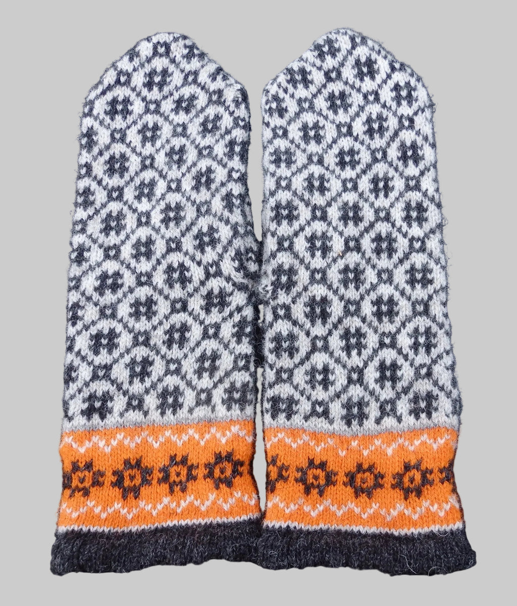Pair of knitted mittens with a geometric pattern on a dark background