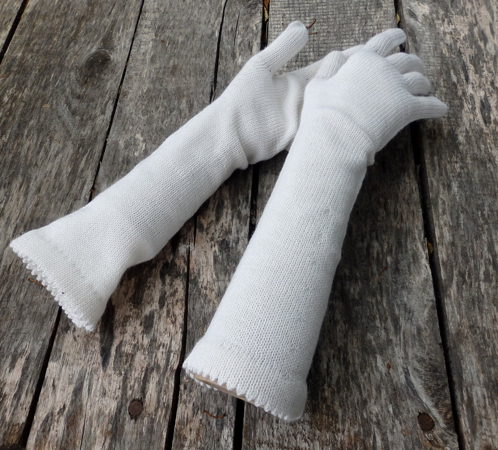 Pair of white gloves on a wooden surface