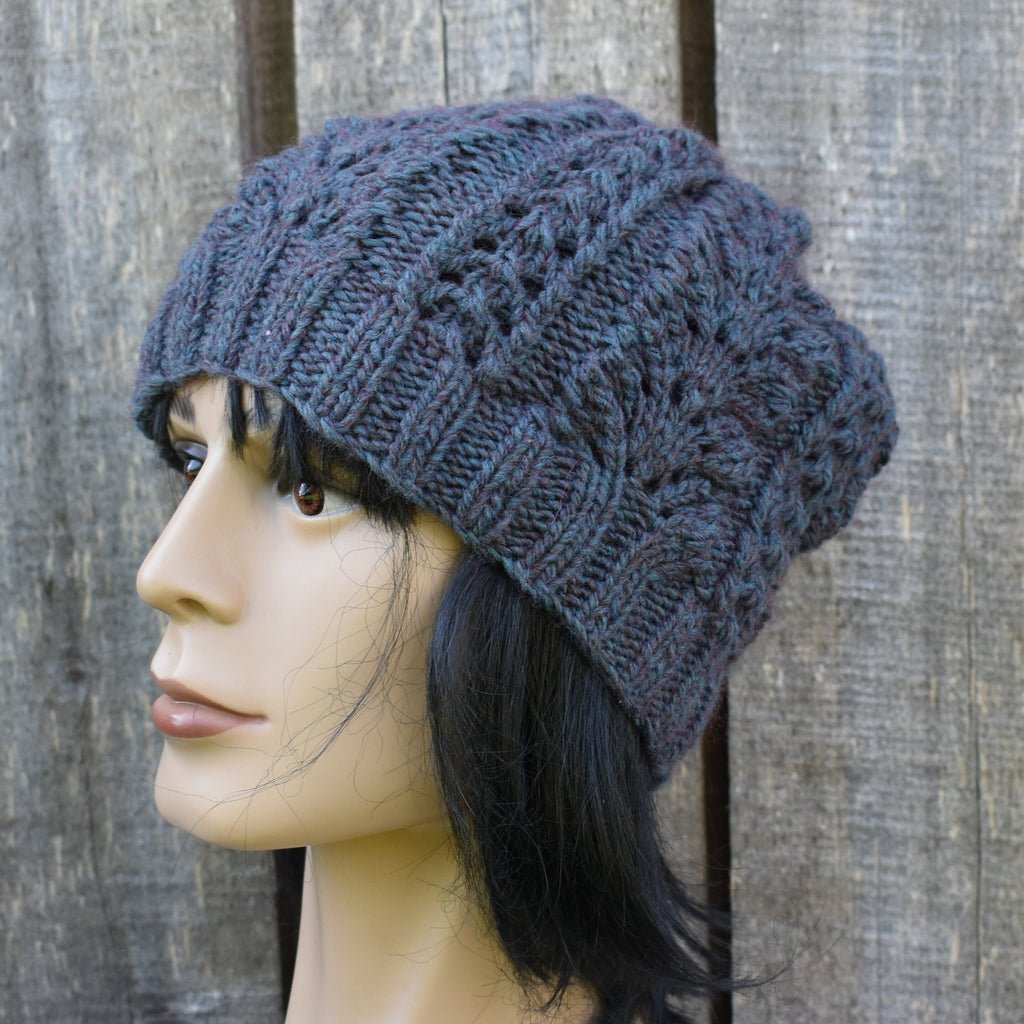 Mannequin head wearing a blue knitted beanie against a wooden background