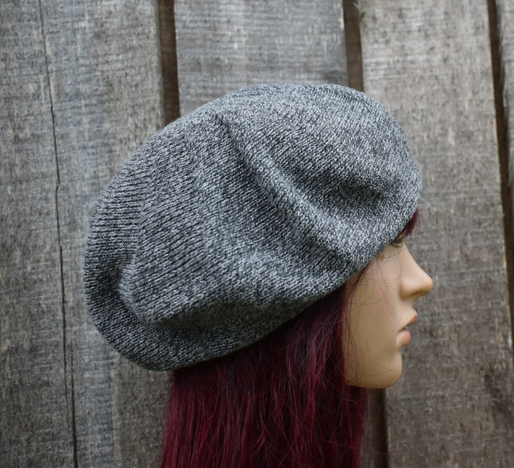 Gray knit beret on a mannequin head against a wooden background