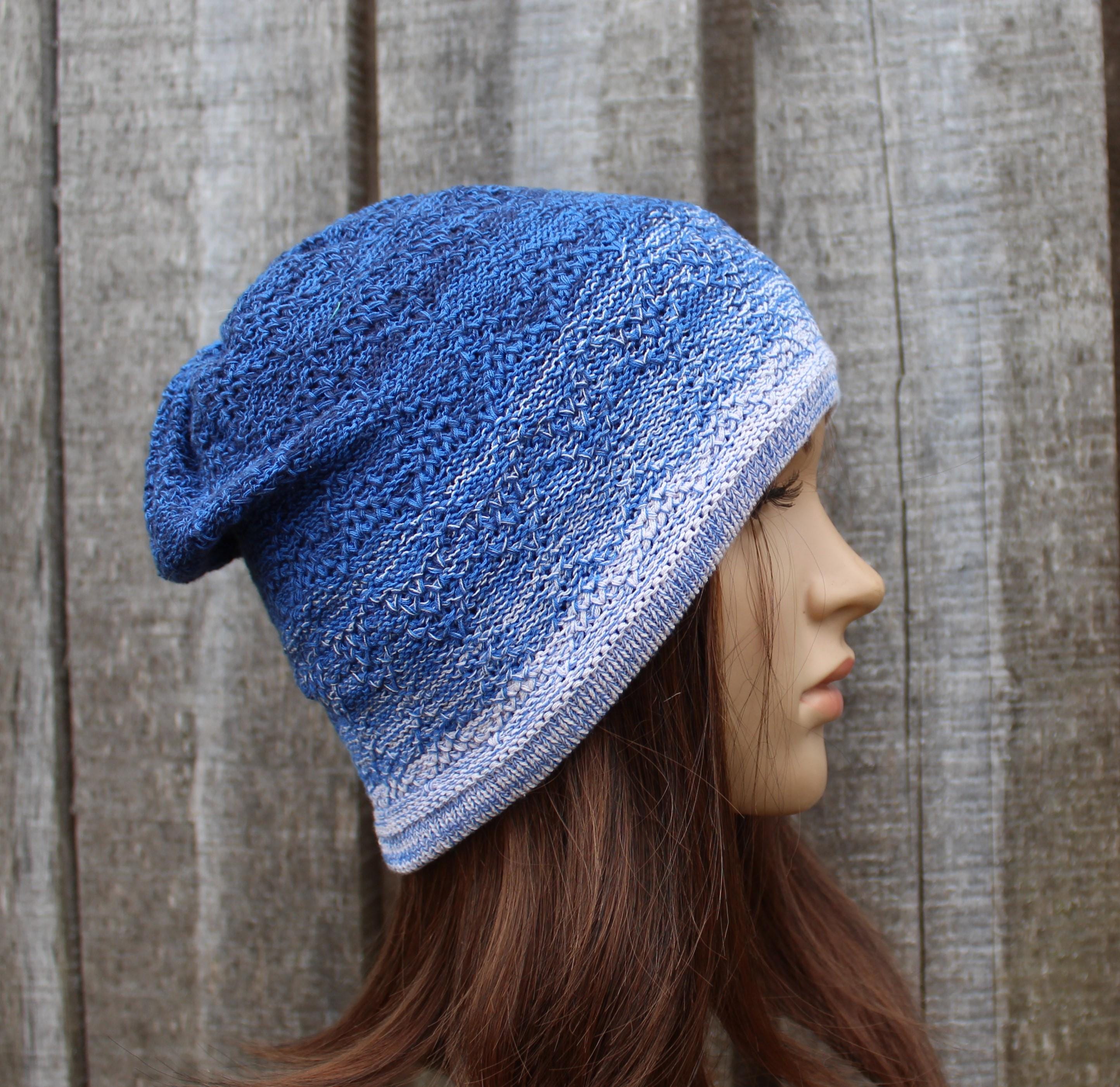 Blue knitted hat on a mannequin head against a wooden background