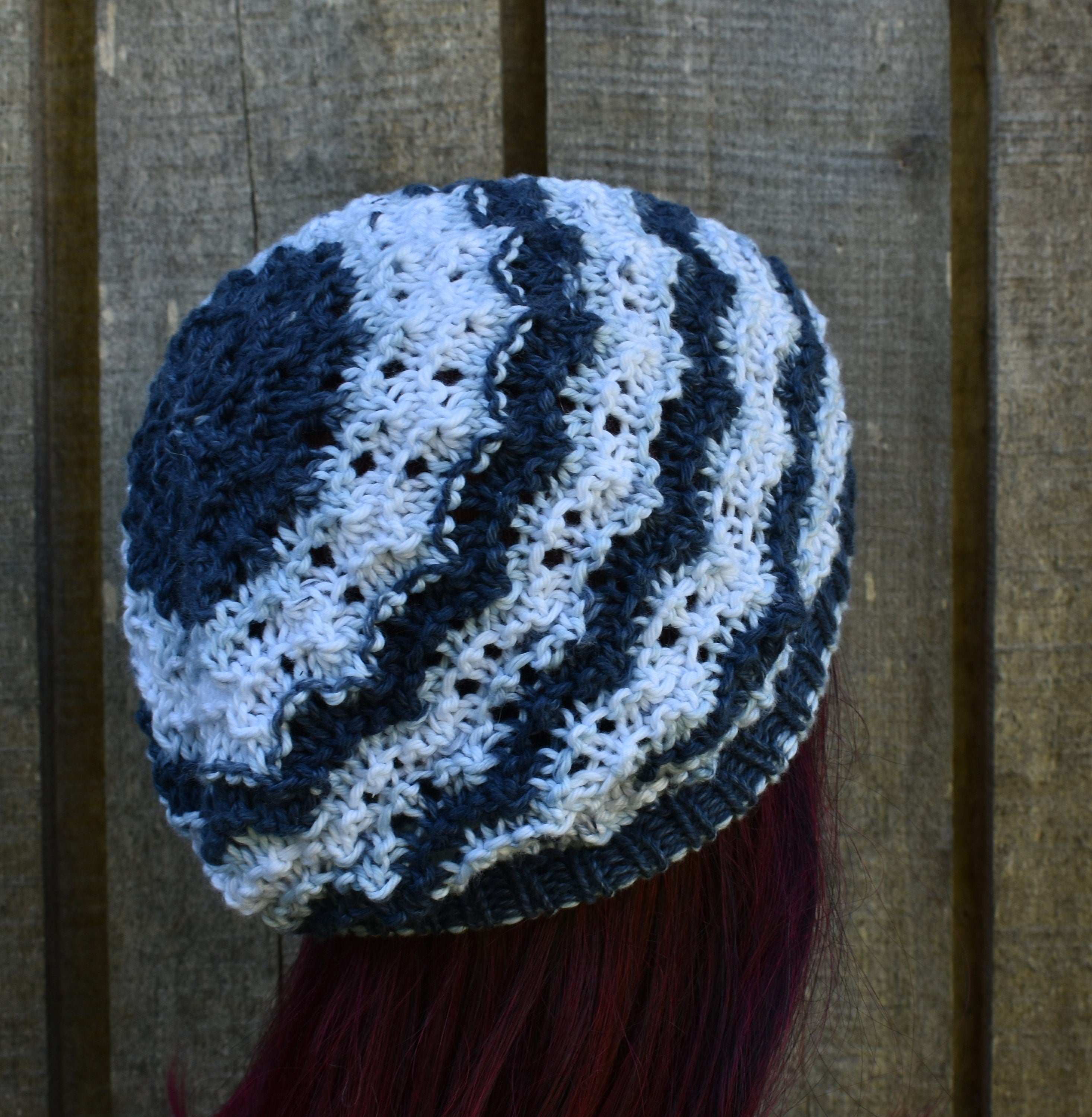 Blue and white striped knit beanie on a wooden background