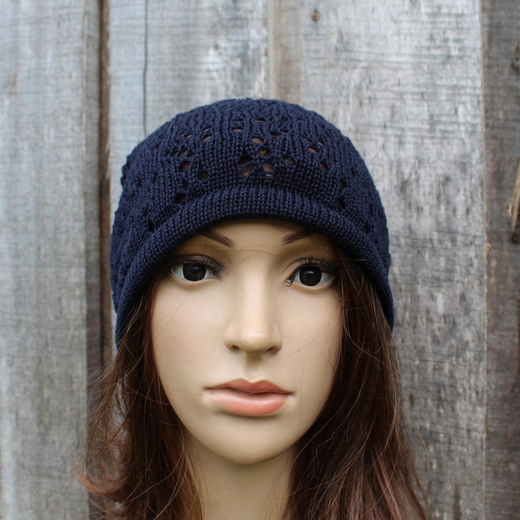 Navy blue knitted hat on a mannequin head against a wooden background