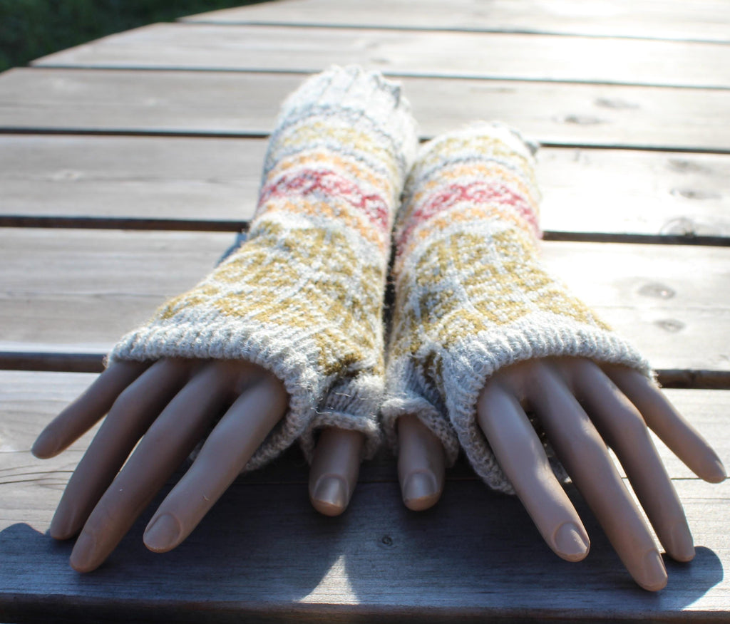 Pair of knitted fingerless gloves on a wooden surface