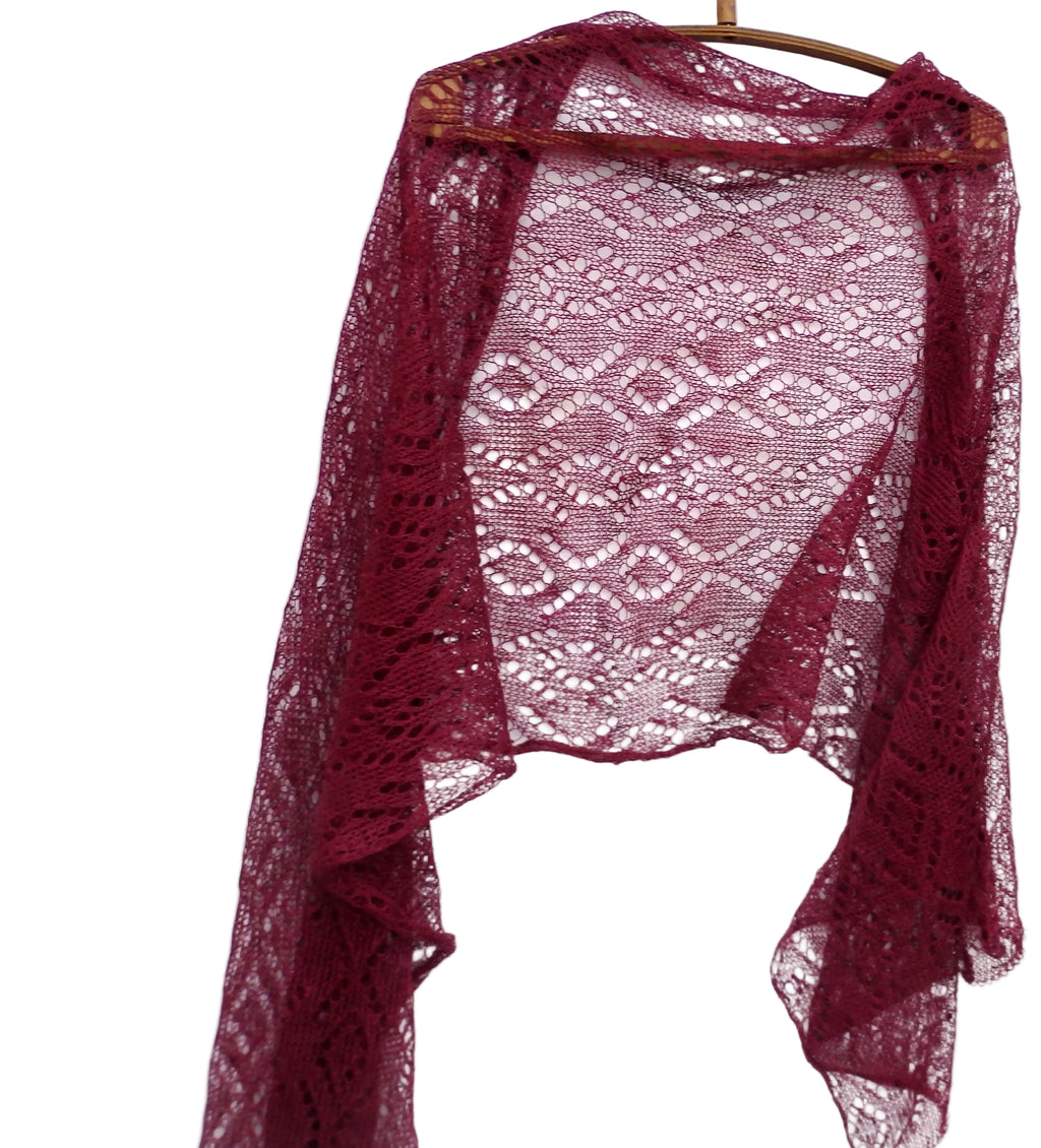 Maroon lace shawl on a wooden hanger against a white background