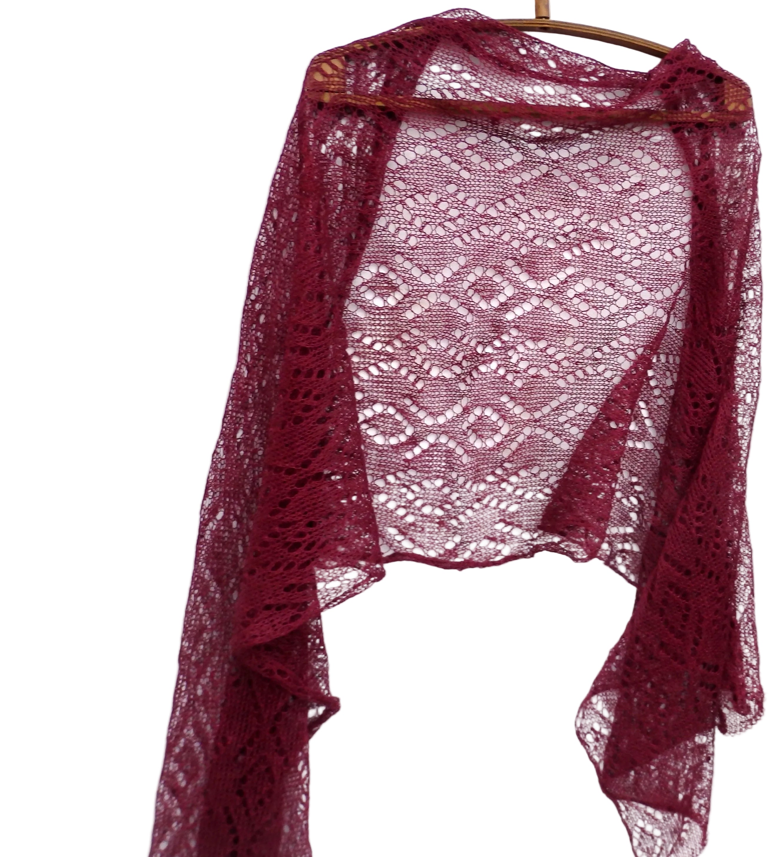 Maroon lace shawl on a wooden hanger against a white background